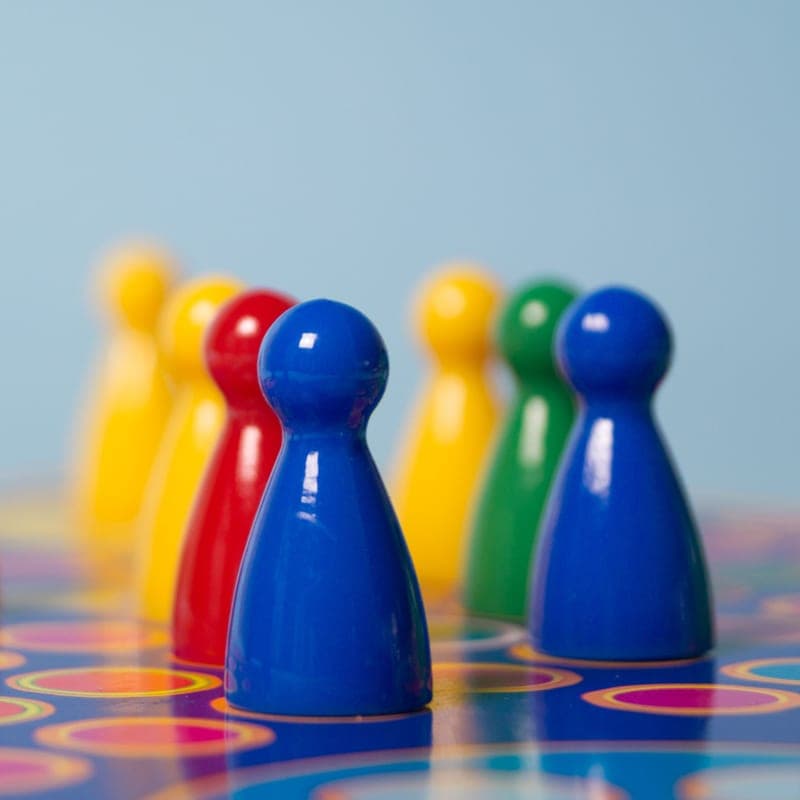 Children playing a colorful board game on a rug - a stand-in for the Outfoxed!, not a photograph of this model
