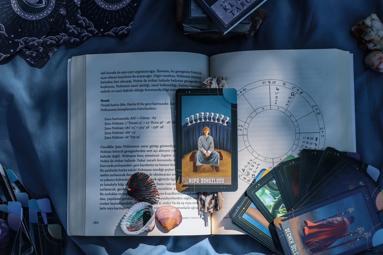 An open rulebook of only a few pages beside a small card game