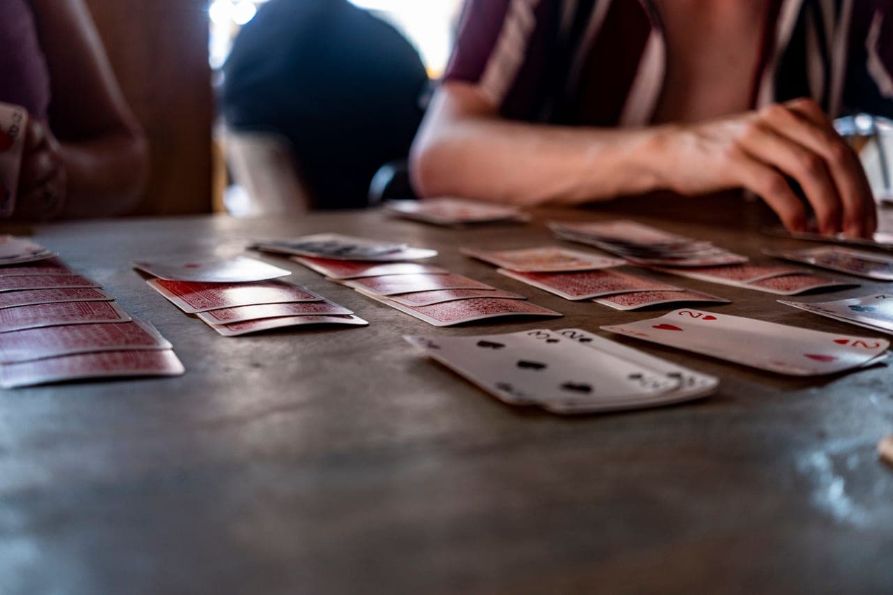 Two players facing each other across a table of cards