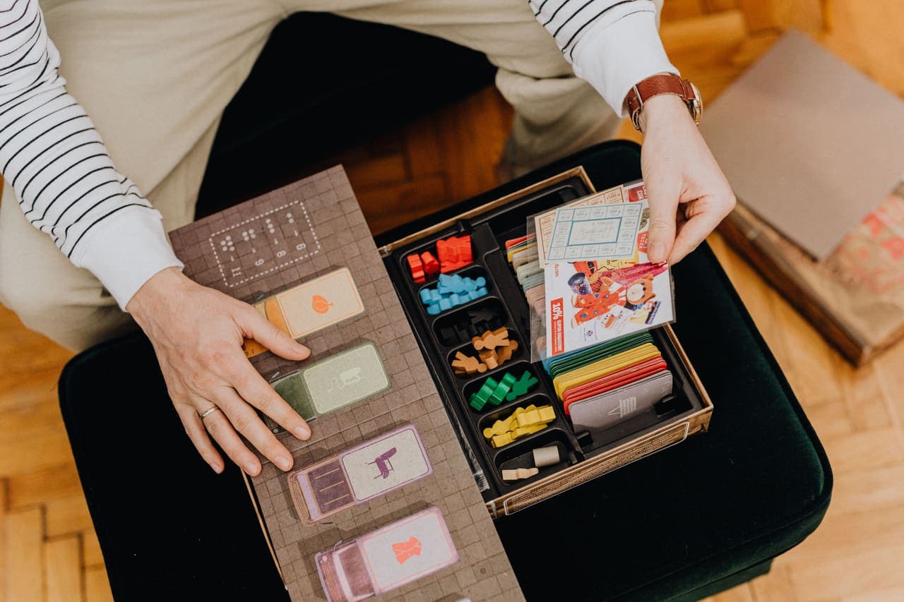 A player lifting components from a well-organized board game box