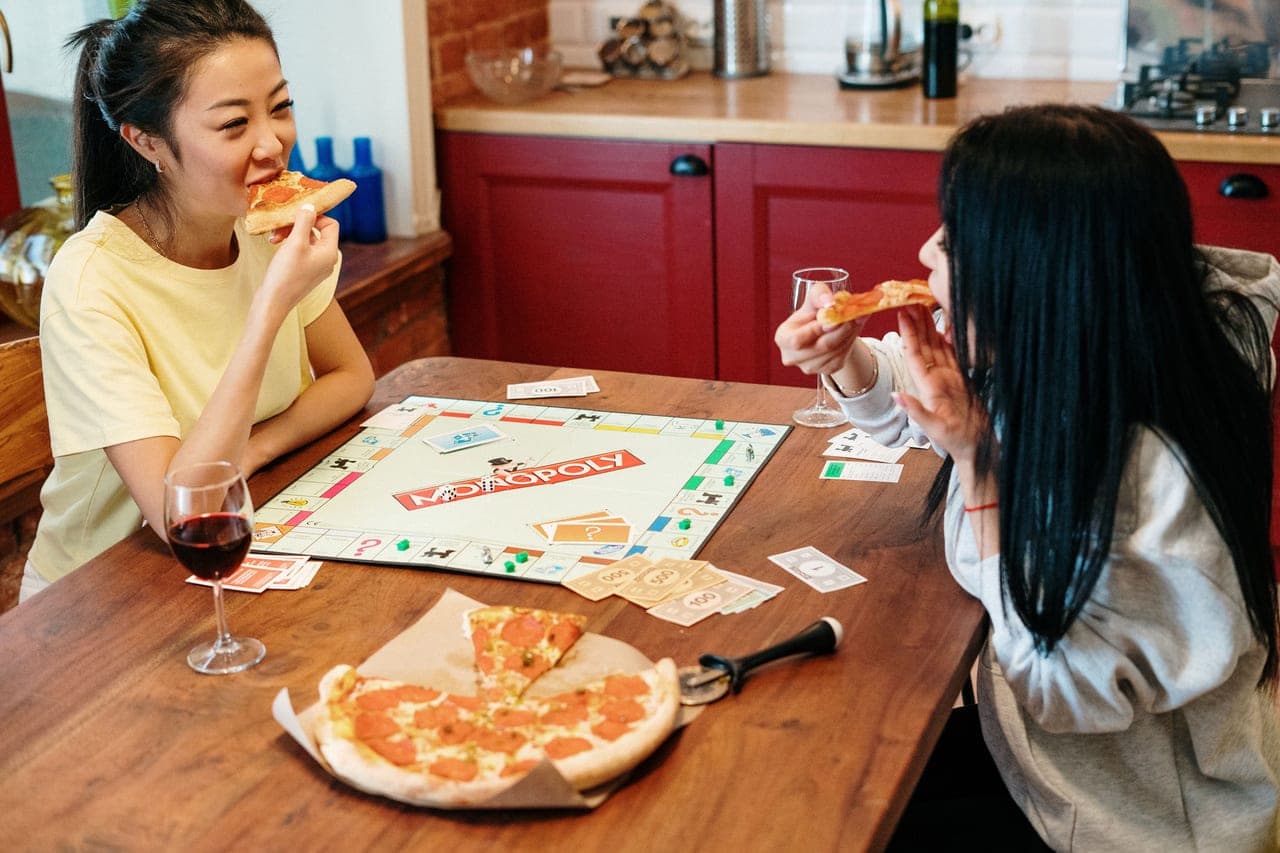 A table set for game night with snacks, glasses and a board game in progress