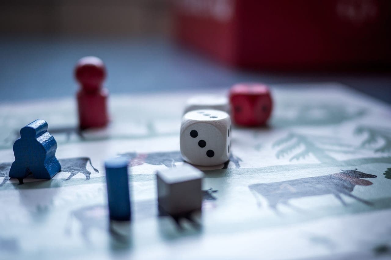 An attractively illustrated board game laid out on a linen tablecloth