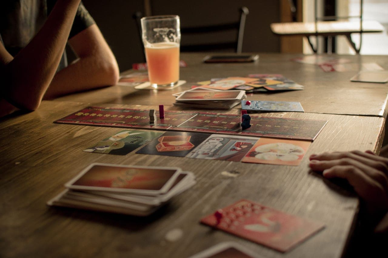 A board game box and a glass of beer on a side table