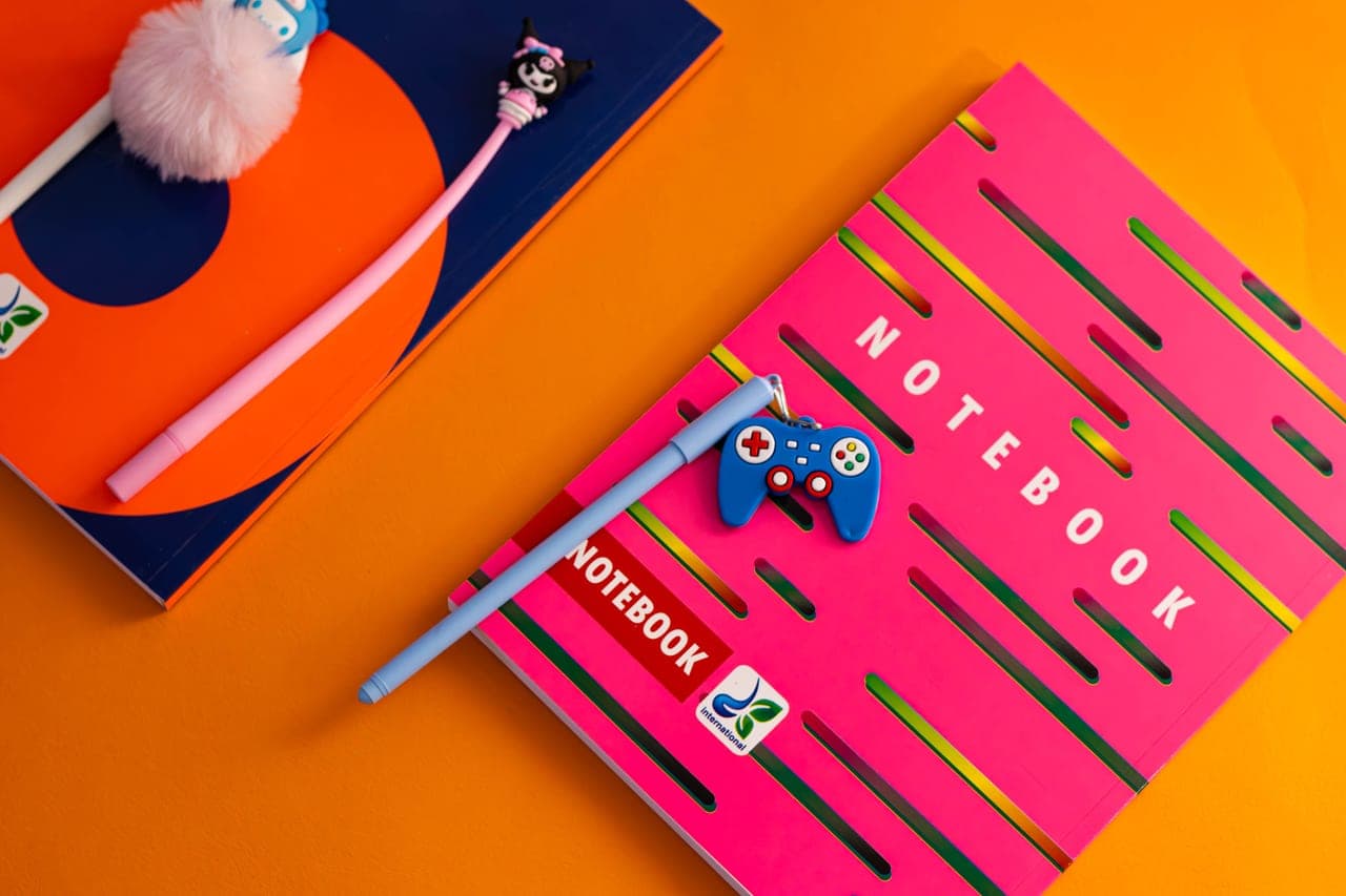 An open notebook and pencil beside a board game box, part-way through a written comparison