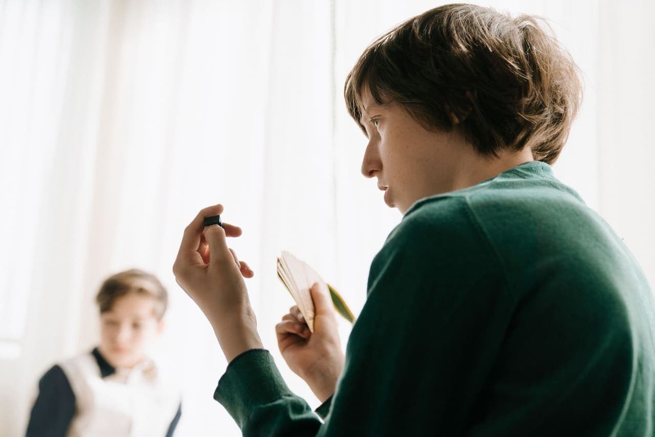 Two children concentrating on a card game indoors
