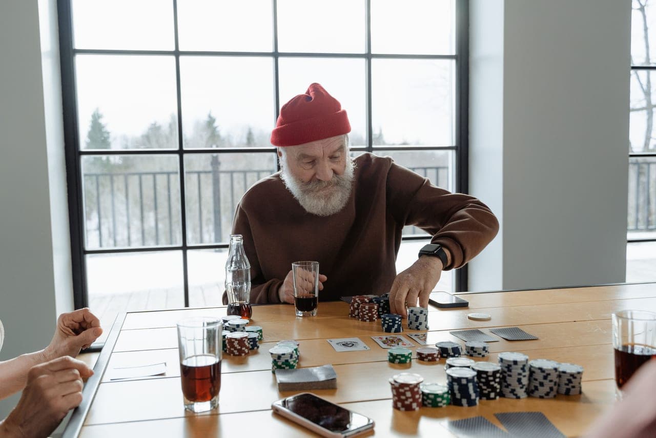 One person playing a board game alone at a table by a window