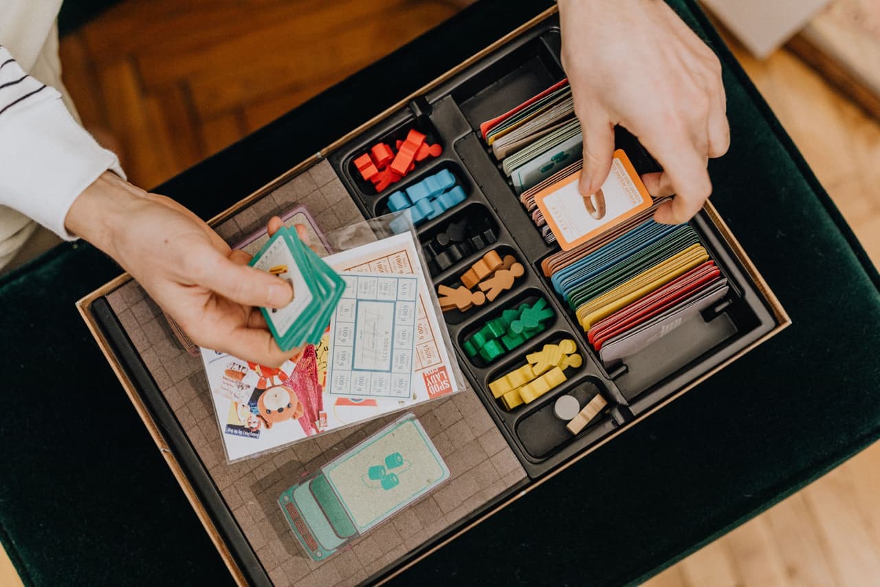 Close-up of board game components: cards, wooden pieces and tiles