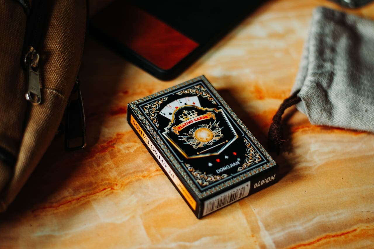 A boxed deck of illustrated cards resting on a pale marble surface