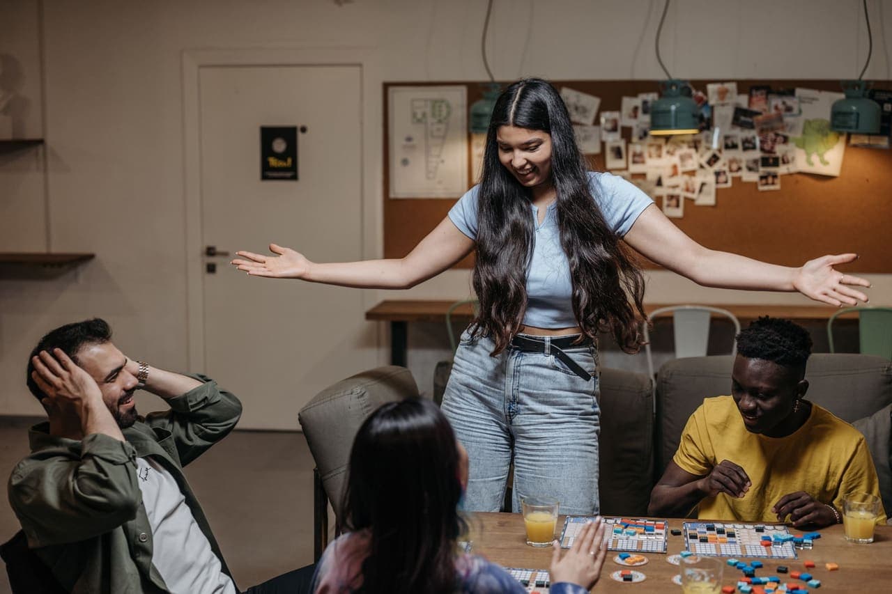 Friends playing a board game together at an indoor table