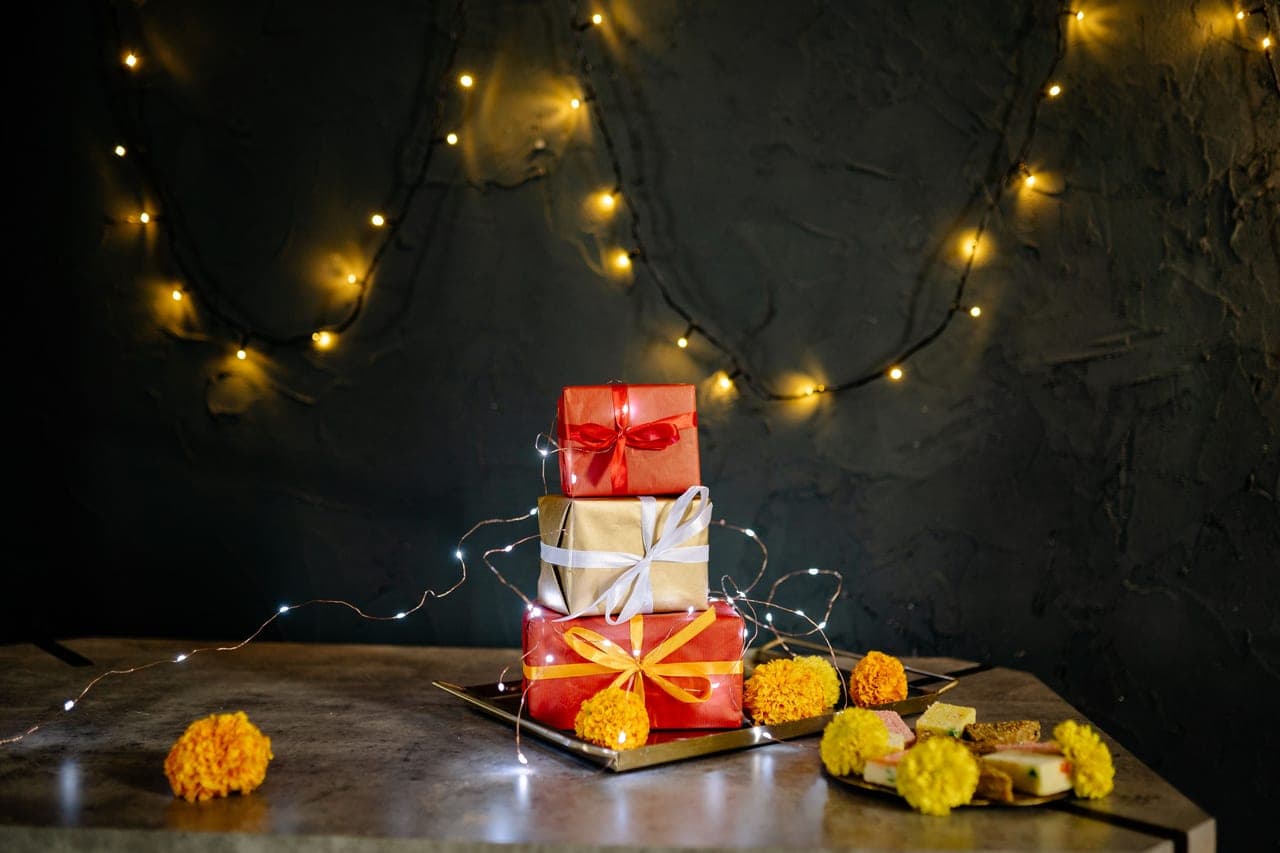 A pile of small wrapped gifts on a table at an office gathering
